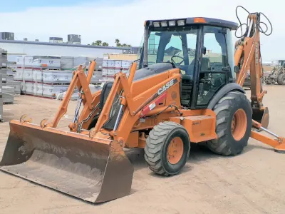 Close-up view of an orange excavator with a rear claw and a large bulldozer positioned in front.