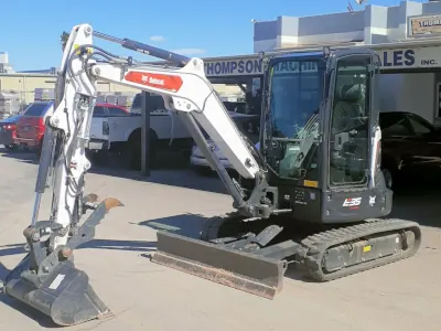 A detailed view of a compact white excavator machine.