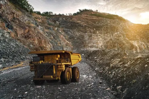 Large dump truck being loaded with minerals for transport at a gold mining site in Thailand.