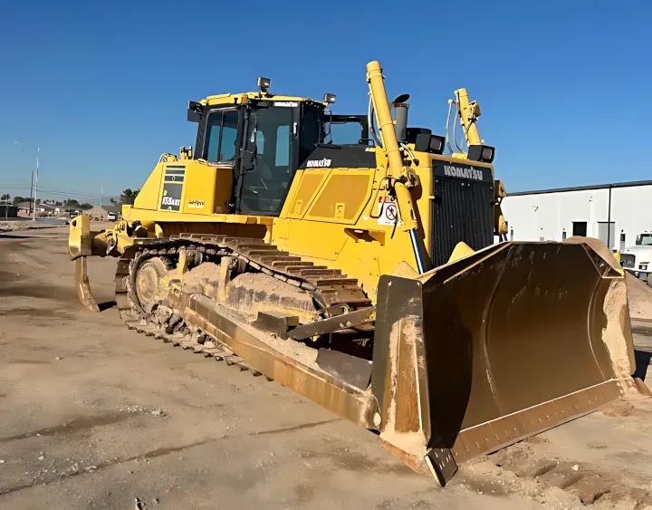 A massive yellow 2019 Komatsu D155 AXI8 bulldozer featuring a large front blade and an empty operator cab, parked on a dirt lot.